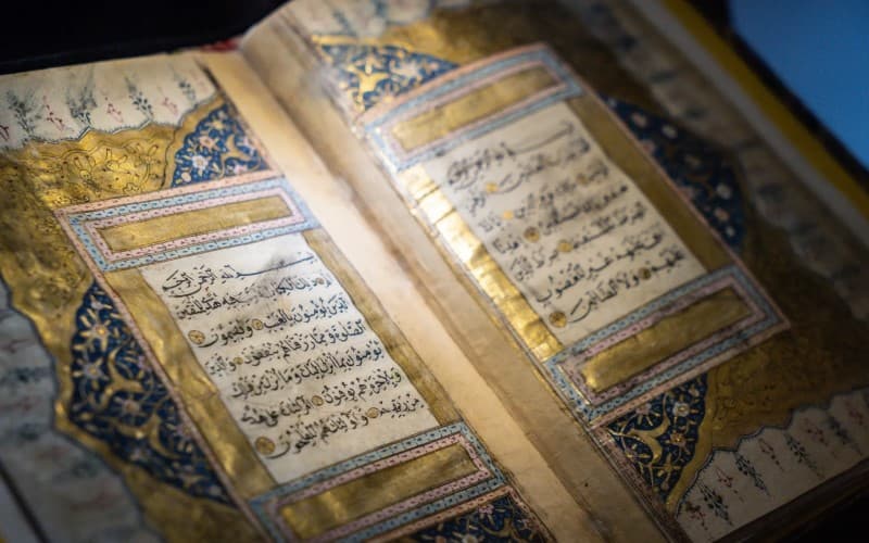 An antique illuminated Qur'an manuscript with gold and Arabic calligraphy